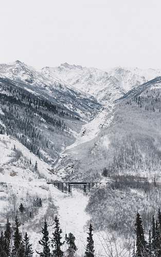 iphone wallpapers black bridge surrounded by mountain covered with snow under white sky iphone backgrounds